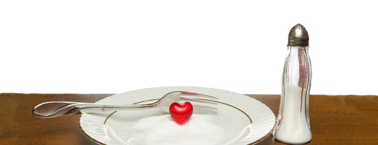 A plastic heart on a plate full of salt