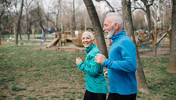 senior couple jogging in park