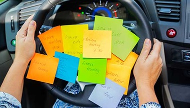 Sticky notes with to-do items on a steering wheel