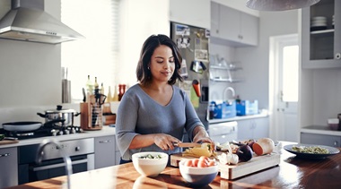 A woman cooks a healthy meal in the kitchen.
