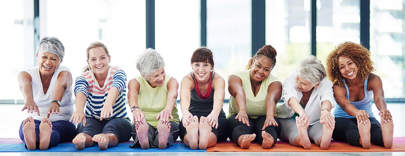 A group of women stretch before a group fitness class.
