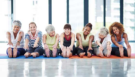 A group of women stretch before a group fitness class.