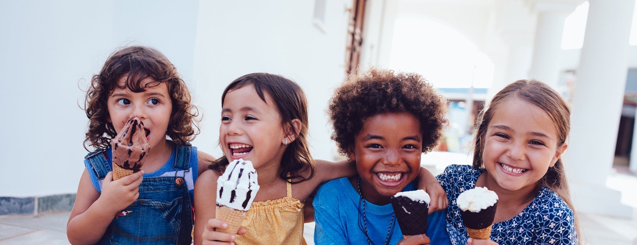a group of children smiling and eating ice cream