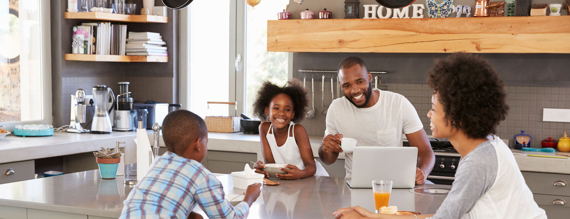 A family sits at the kitchen table enjoying breakfast