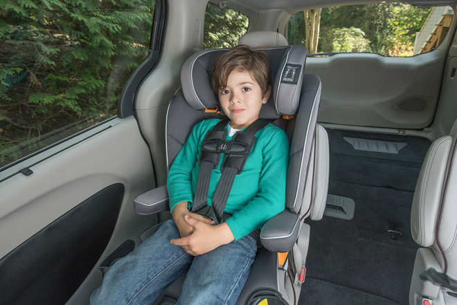 A young child sits in a forward-facing car seat