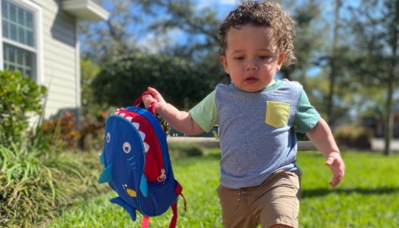 Kid running and holding a backpack