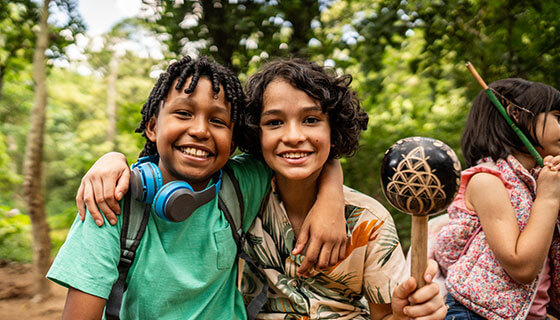 Two children embrace during outdoor summer camp