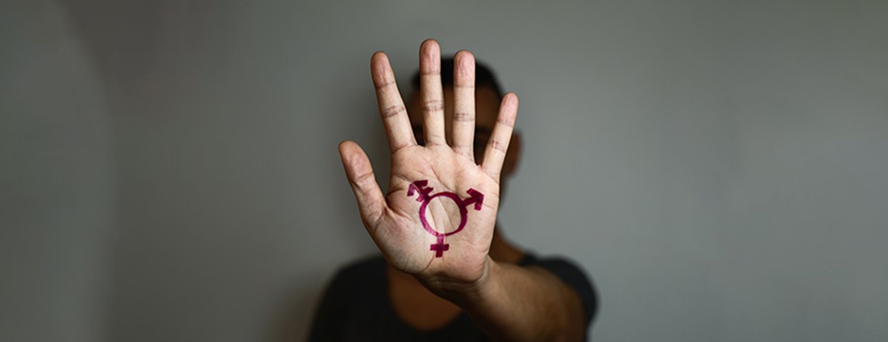 A person holds up their hand, with gender symbols drawn on their palm.