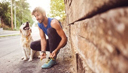 Man prepares to go on jog with his dog.