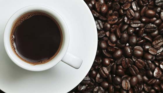 Cup of coffee sitting atop coffee beans