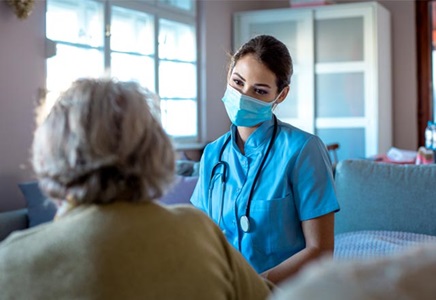 A nurse provides care to her elderly patient