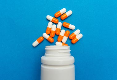 Pill capsules spilling out of a medicine bottle