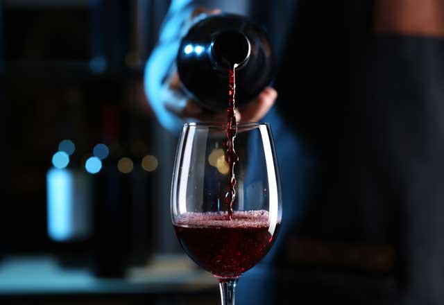 Person pouring a wine glass