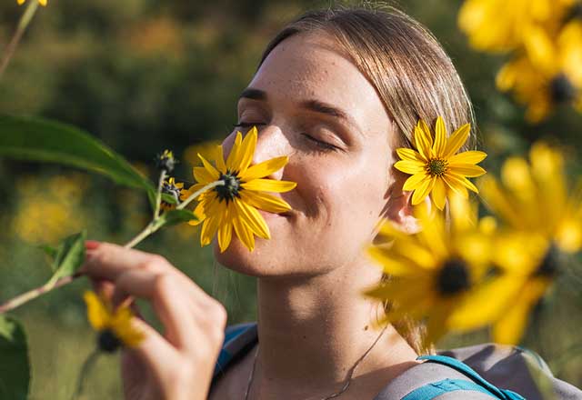 Woman smelling daisies in a field