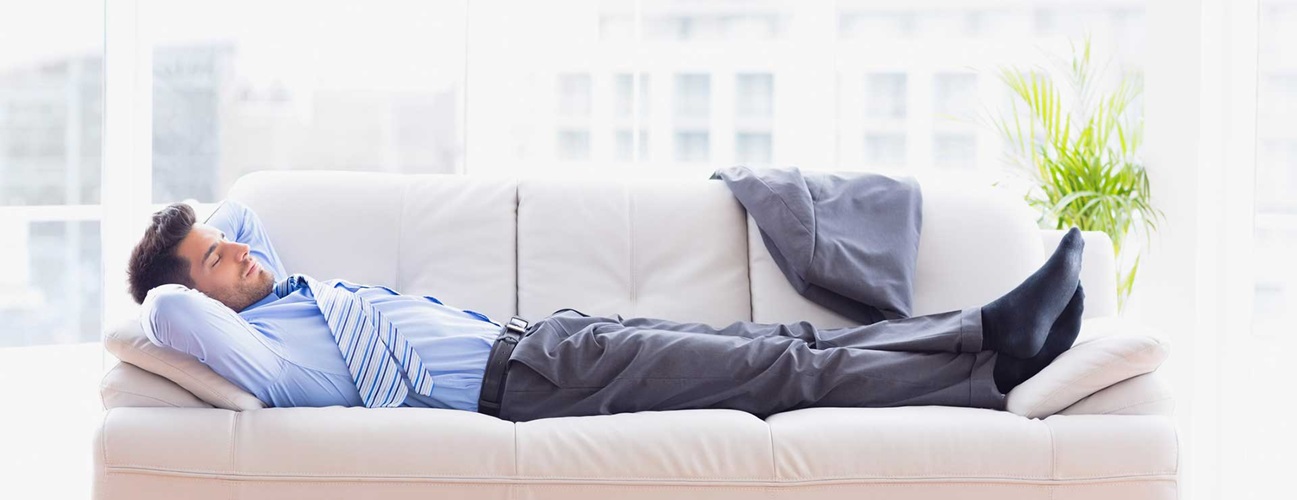 Tired business man sleeps on sofa in work clothes
