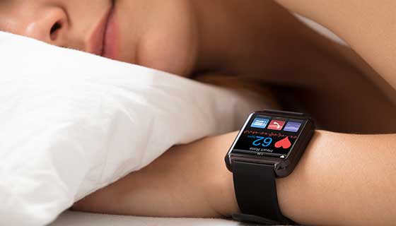 A person sleeping with a smart watch tracking their sleep