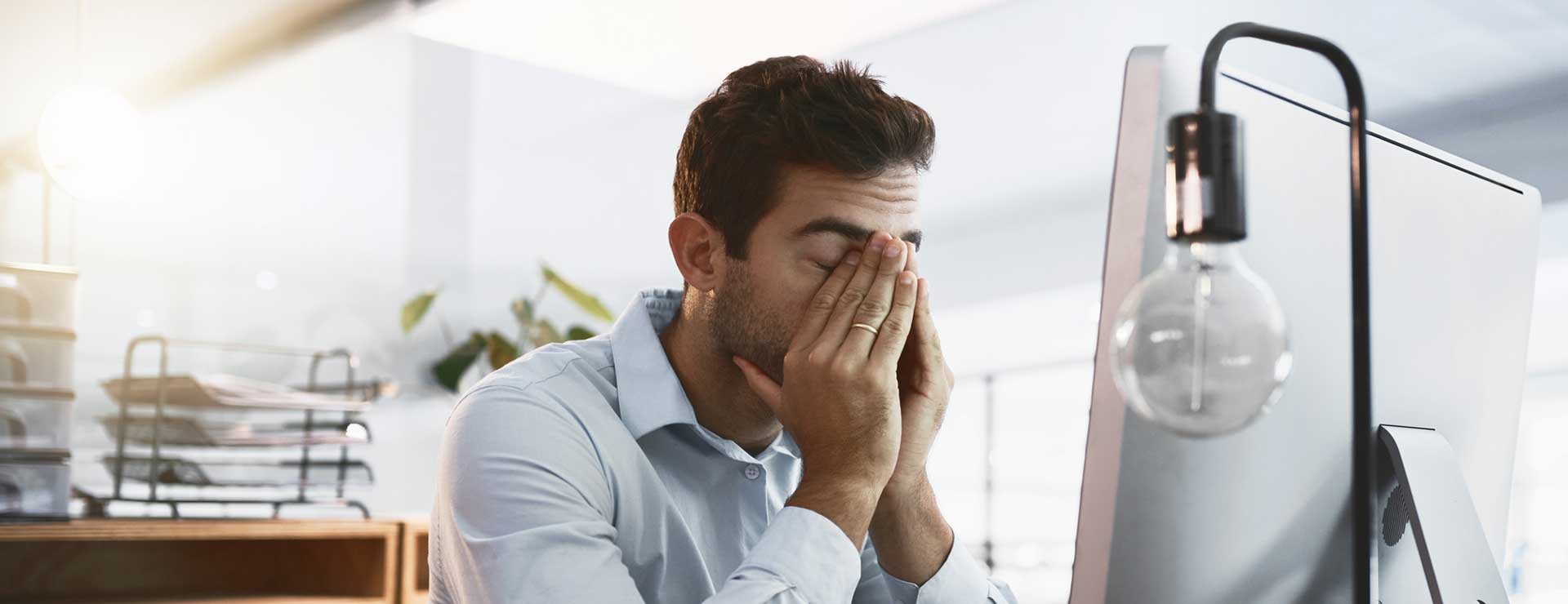 tired man yawning at his desk at work
