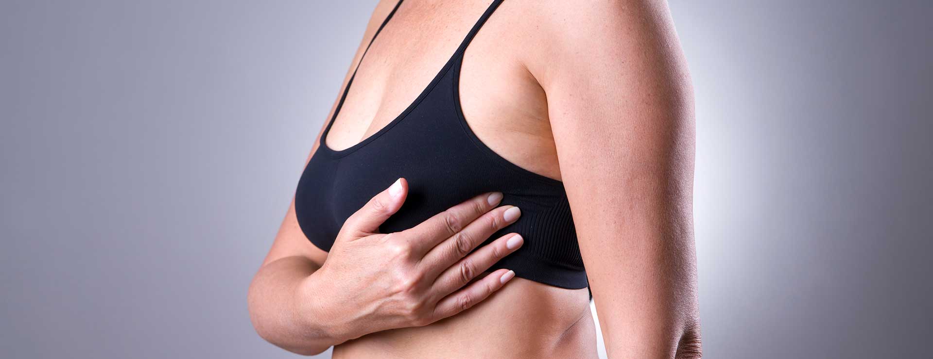 woman examining her breasts for cancer