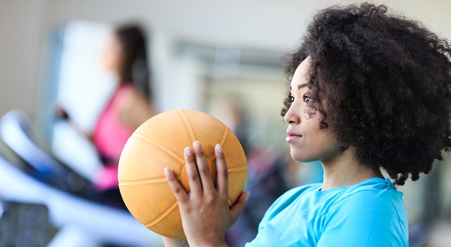 Young woman working out at gym with medicine ball