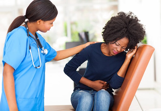 Woman explains stomach pain to doctor