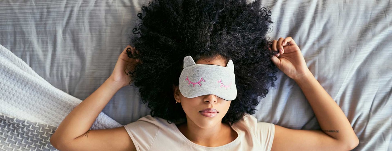 Woman in bed with sleep mask on