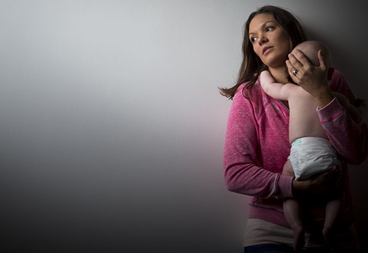 stressed-looking woman holds baby
