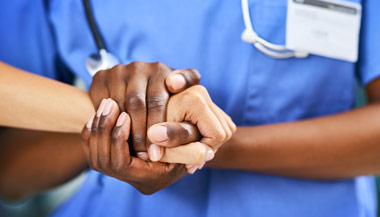 Healthcare worker holding patients hand