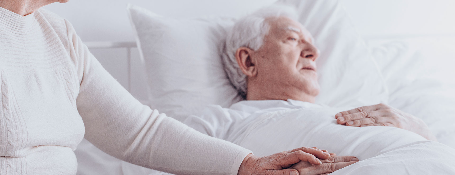 man in bed with a woman's hand holding his