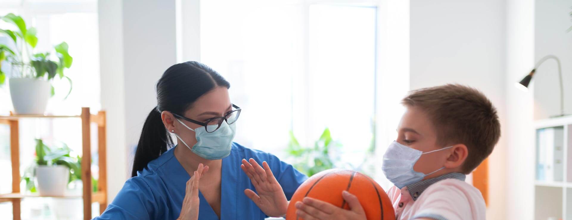 Pediatric physical therapist treating a child at home