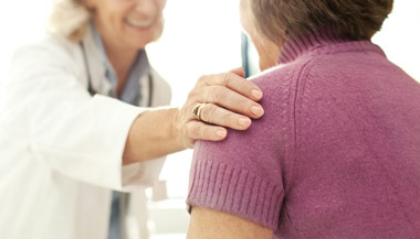 Doctor comforting patient by placing their hand on the patient's shoulder