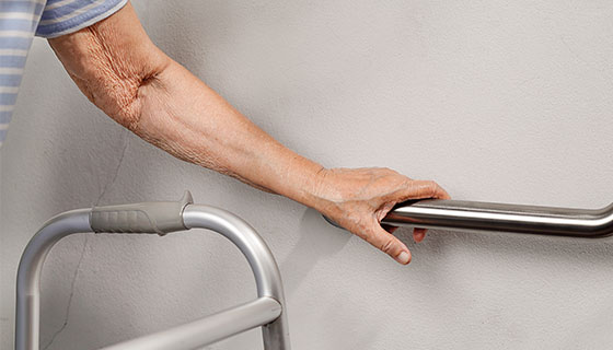 hand using a walker and safety railing teaser