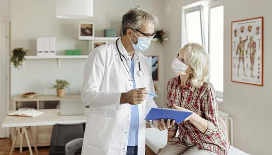 Cardiologist speaking with patient in a sunny patient room