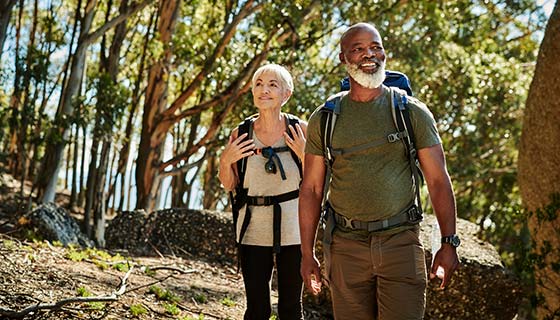 Couple hiking up a lakeside slope during fall