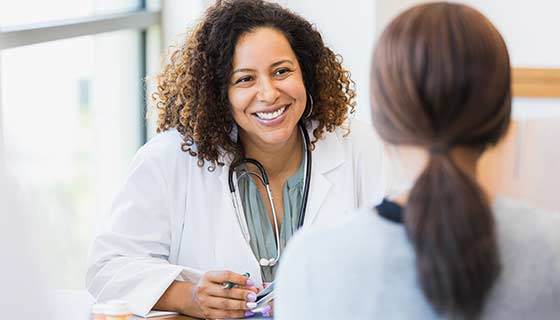 Surgeon speaking with patient in an exam room