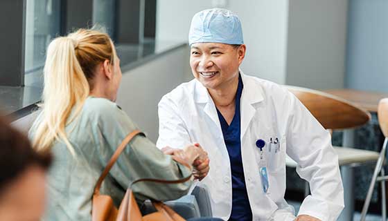 Surgeon shakes a caregiver's hand in the waiting area