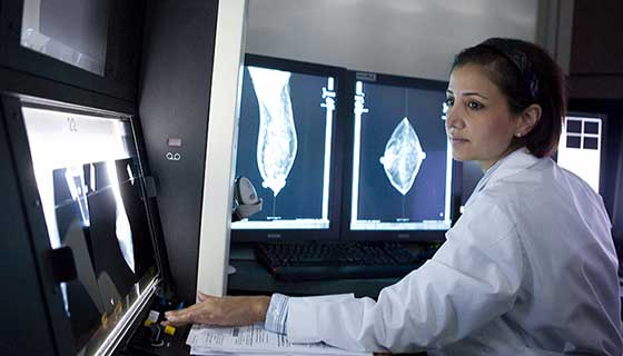 Doctor Razavi examines scans on a computer monitor