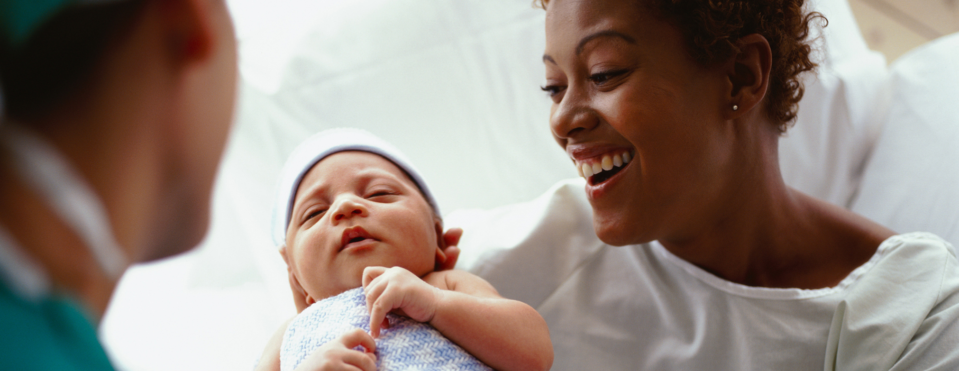 doctor handing mother her newborn baby