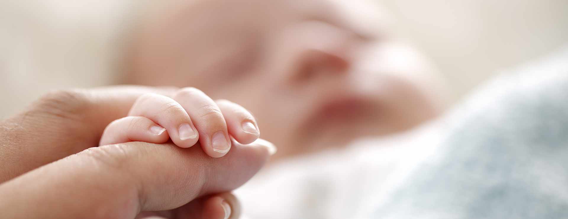baby holding mother's finger