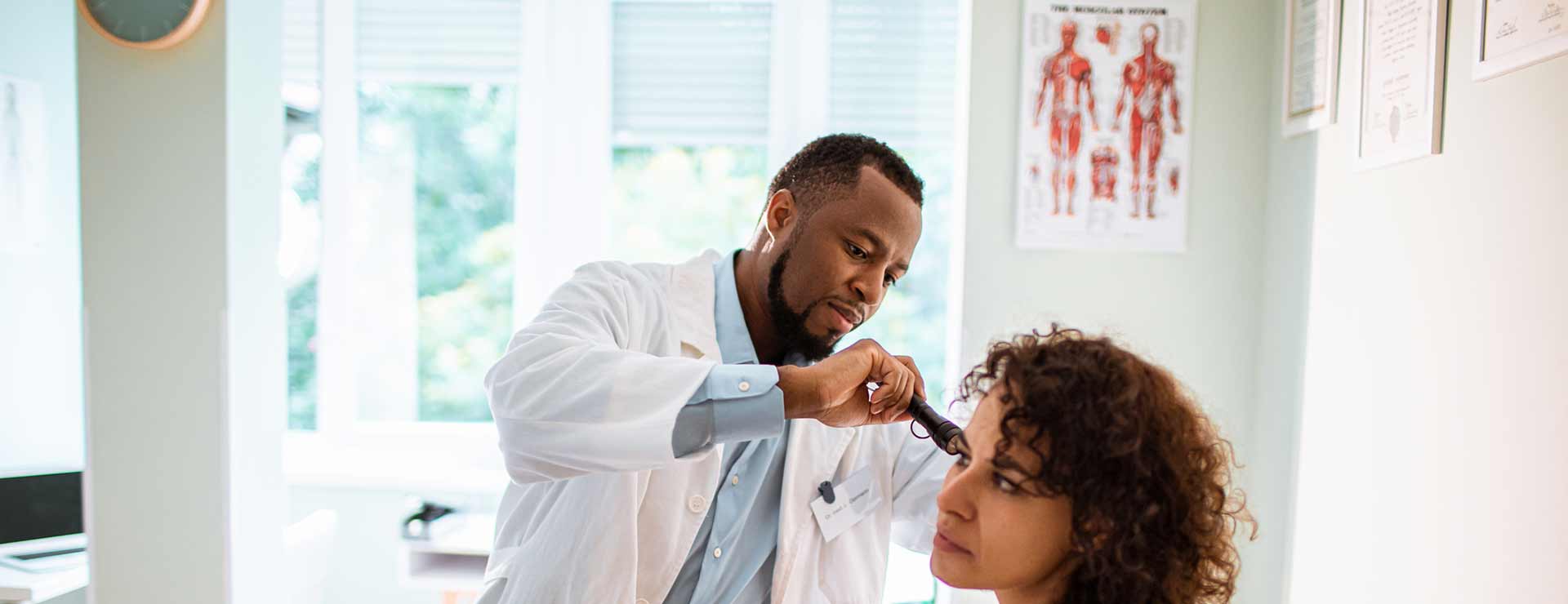 Doctor checking patients ear. 