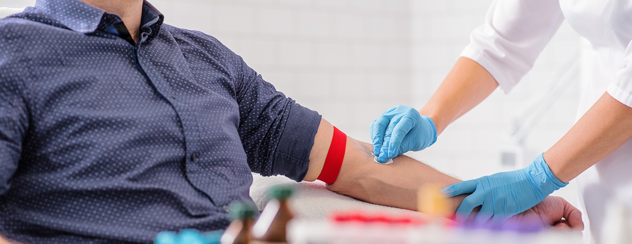 doctor drawing blood from patient's arm