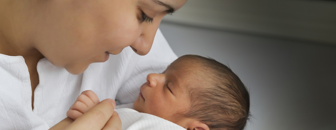 woman holding sleeping newborn
