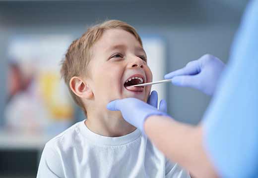 kid getting tonsils checked. 
