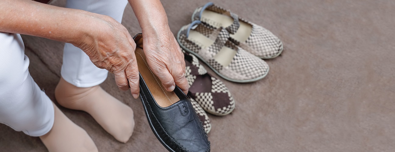 woman with swollen feet putting on shoe
