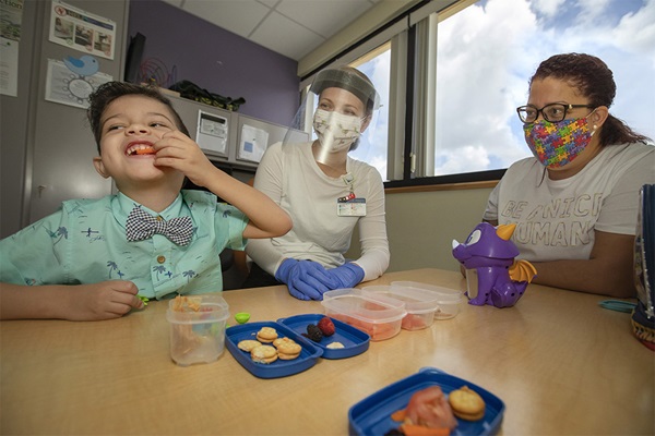 Gabriel works with Barbara Hancock, center, a speech-language pathologist at Johns Hopkins All Children's Hospital, as his mom Cherry looks on.