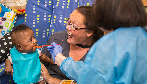 Baby Kimbriah eating with Johns Hopkins All Children's team members.