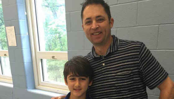 Neale, looking healthy, smiling with a young boy.