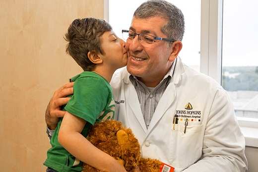 George Jallo, M.D. receives a kiss as thanks from Rafael for removing a tumor from the Brazilian boy's spinal cord.