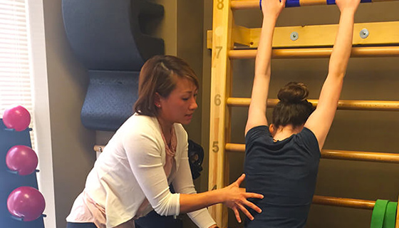 Lien assists Sophie with Schroth exercises