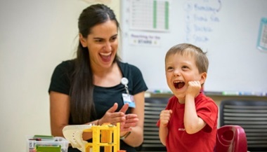 Tucker and speech language pathologist smiling at Johns Hopkins All Children’s Hospital