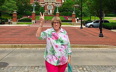 Sandy Bass flashes a victory sign in front of The Johns Hopkins Hospital